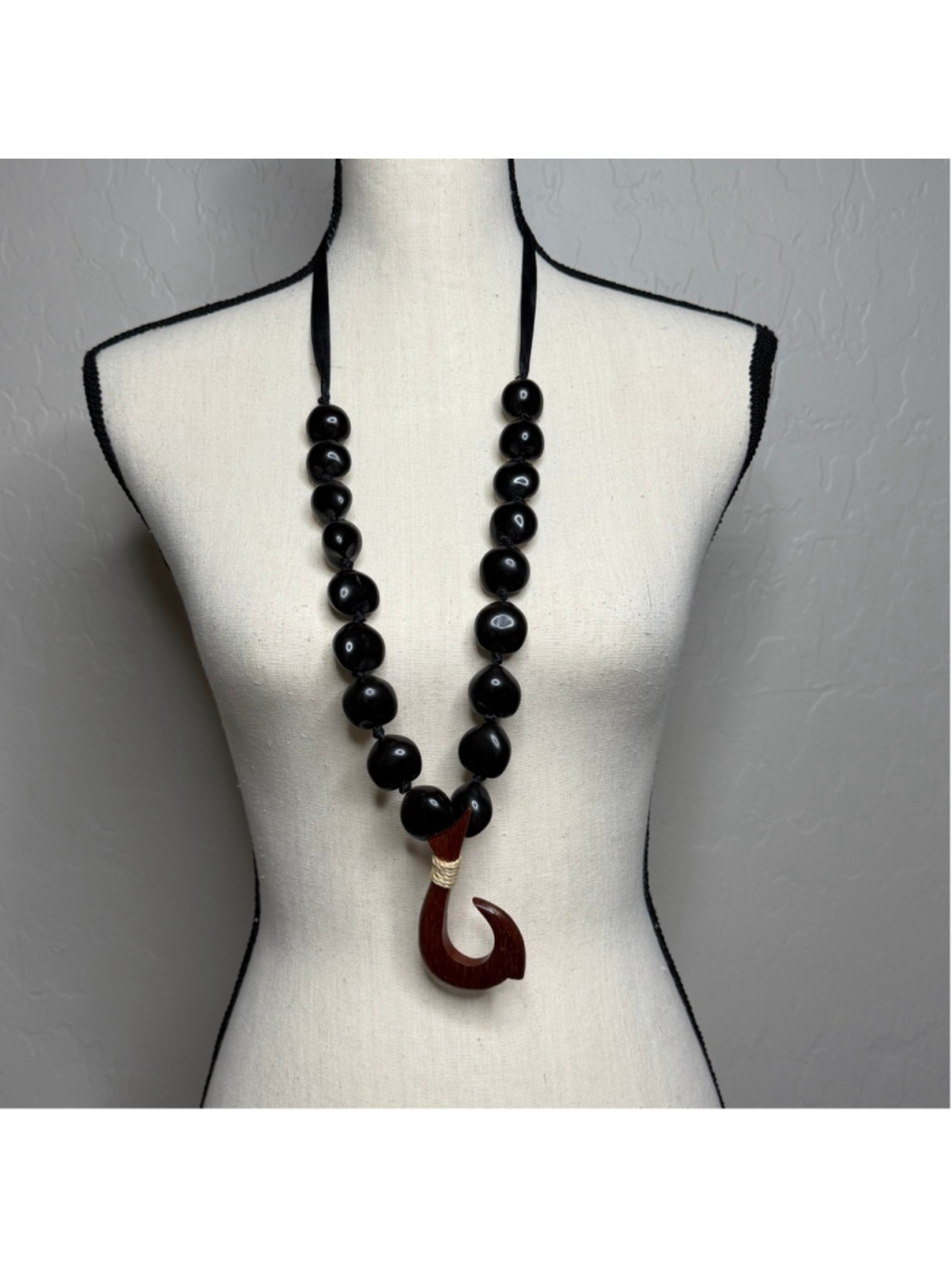 black kukui nut lei with a wooden fish hook pendant